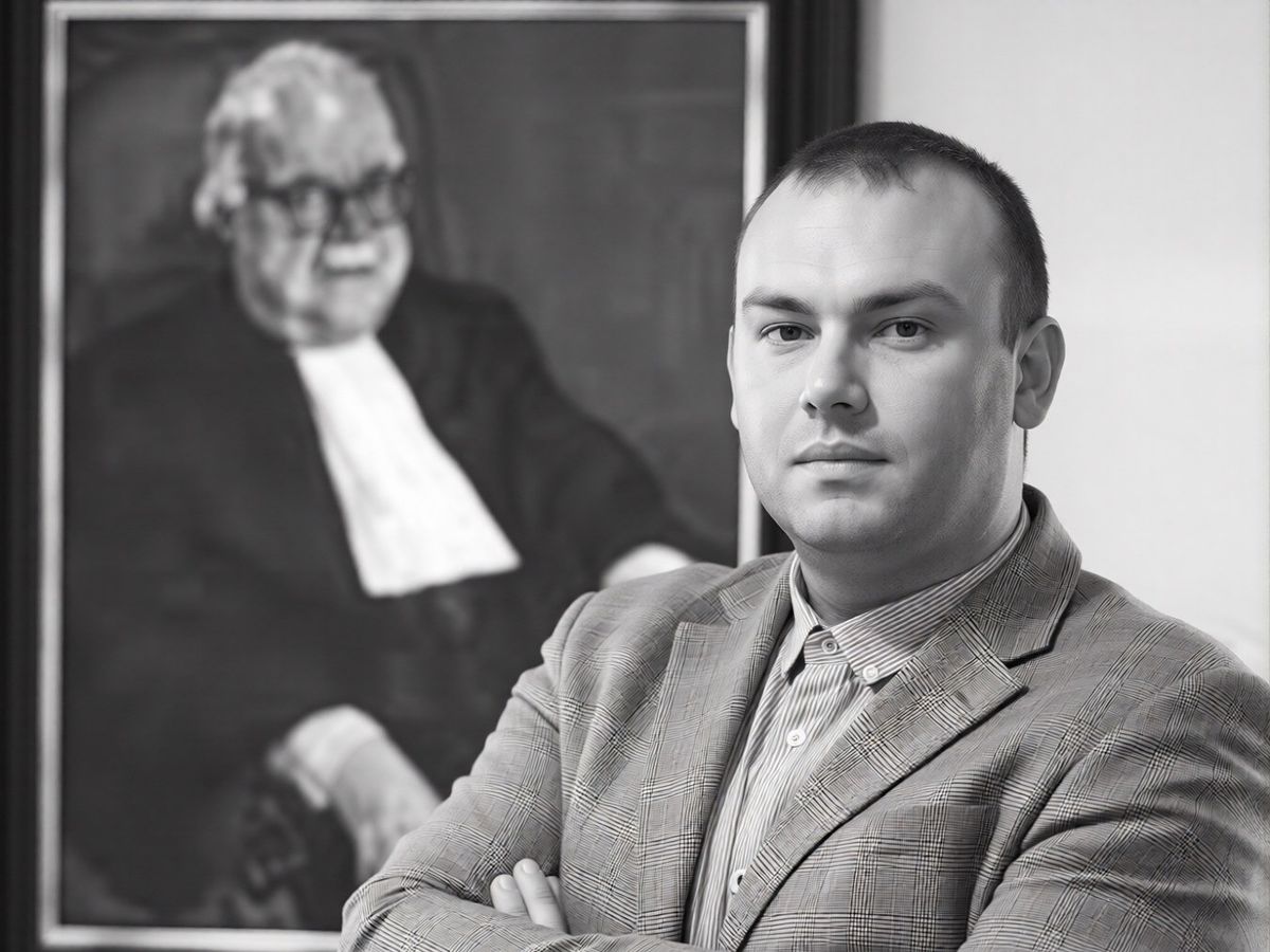 mr. Ikiz voor het portret van een oude meester in toga